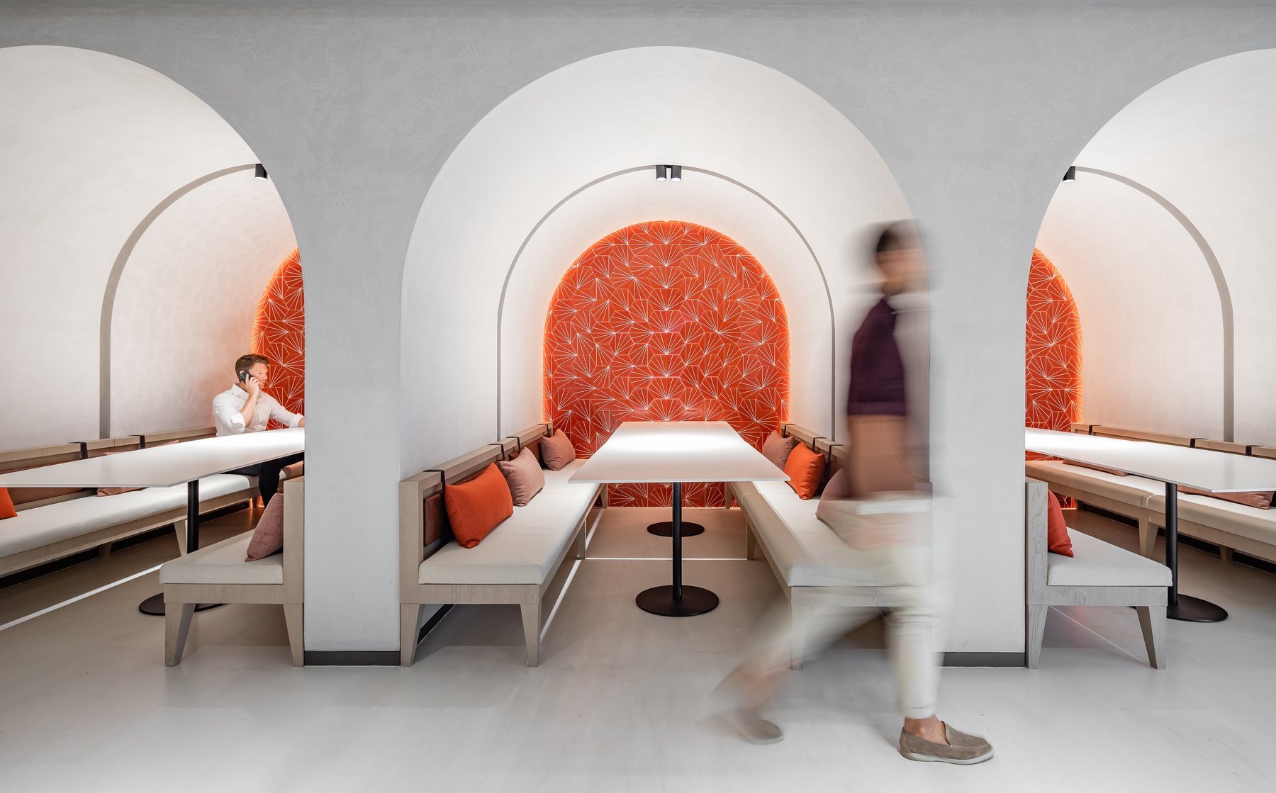 Arched booths with terracotta panels in a workspace